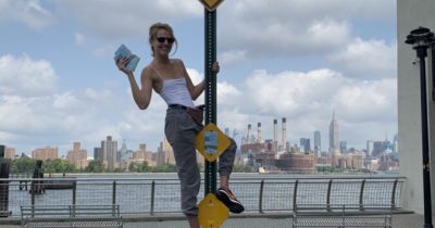 RU artist Brigita Antoni places "Dead End" stickers in Williamsburg, Brooklyn.